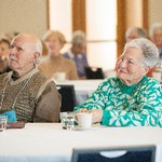 A man and woman seated at a table focusing off screen